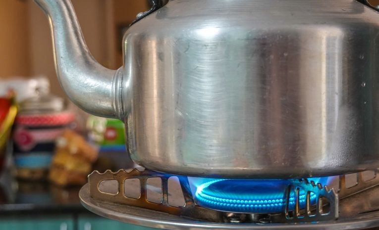 Stainless steel kettle heating on a stove