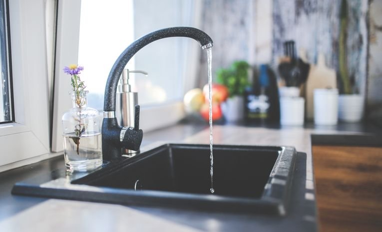 Water flowing from a kitchen tap into a sink