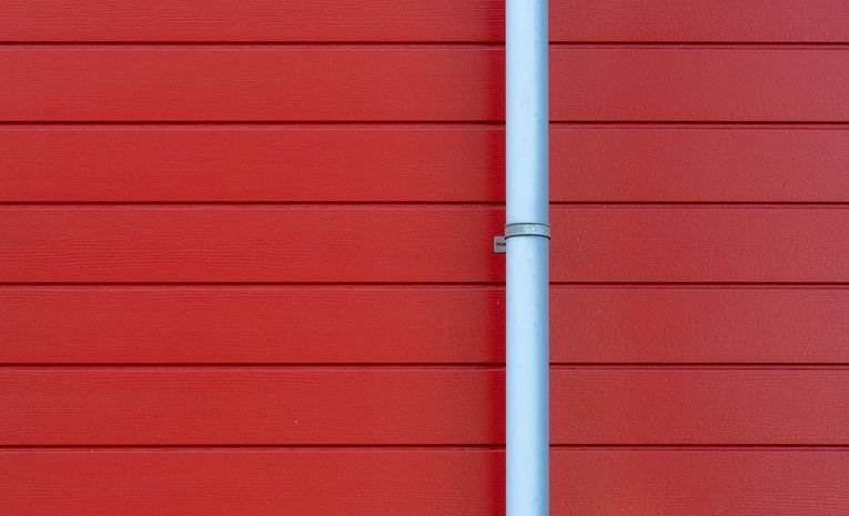 White rain gutter mounted on a house wall
