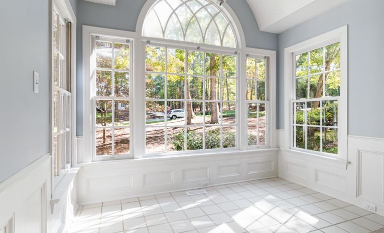 Large glass windows with white wooden frame in a sunroom