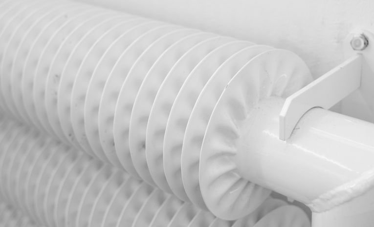 White finned radiator mounted on a home wall