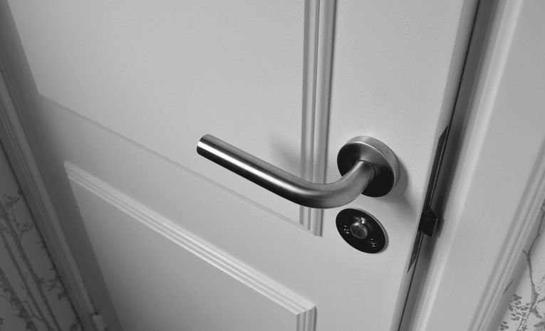 Semi open white wooden door with visible hinges