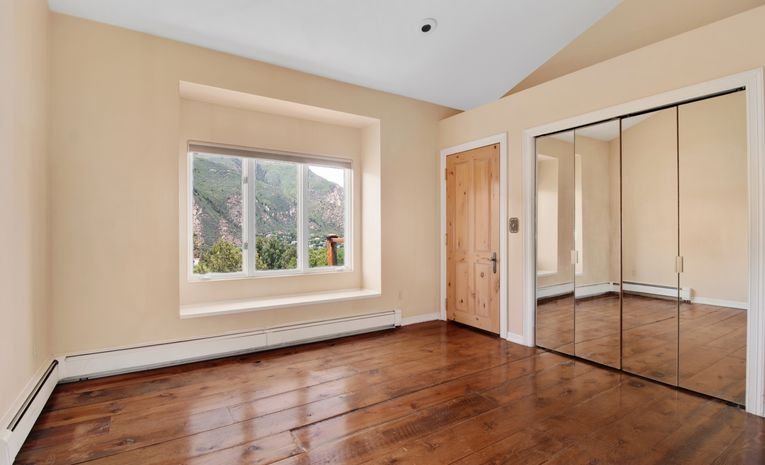 Empty room with wooden floorboards and large window